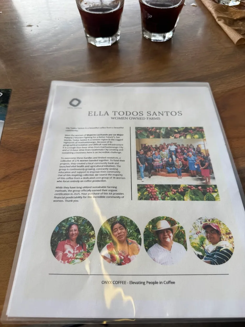 Coffee info sheet. It reads: Ella Todos Santos Women Owned Farms
Ella Todos Santos is a beautiful coffee from a beautiful community.
Meet the women of Mujeres Luchando por un Mejor
Futuro ("Women Fighting for a Better Future"). San
Martin, Todos Santos is a remote region in the rugged highlands of Huehuetenango. Because of its geographical isolation and difficult road infrastructure it is a tough four-hour drive from Huehuetenango City and a 12-hour drive from Guatemala City creating and sustaining a business here is an incredible challenge.
To overcome these hurdles and limited resources, a collective of 276 women banded together. To fund their projects, they created a local community bank and launched vital health and agricultural initiatives. The group is continuously growing, constantly seeking education and support to improve their community.
Out of this inspiring collective, we source the majority of this coffee from a dedicated core group of 36 women who focus entirely on coffee production.
While they have long utilized sustainable farming methods, the group officially earned their organic certification in 2025. Your purchase of this lot provides financial predictability for this incredible community of women. Thank you.